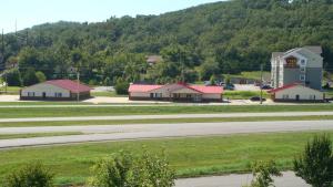 a group of buildings and a road in front of a mountain at Regency 7 Motel in Fayetteville