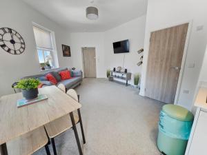 a living room with a couch and a table at Spacious Stylish Apartment in Swindon Town Centre in Swindon