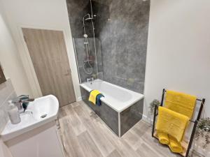 a bathroom with a sink and a shower and a white sink at Spacious Stylish Apartment in Swindon Town Centre in Swindon