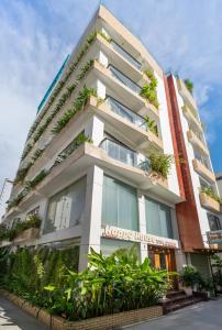 un grand bâtiment blanc avec des plantes dessus dans l'établissement Happy House Hotel & Apartment, à Đà Nẵng