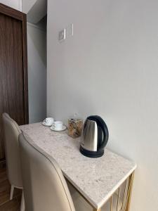 a table with chairs and a tea kettle on it at Tilal Al-Qattara in Mashūq