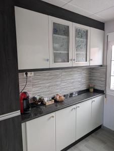 a kitchen with white cabinets and a black counter top at Olladas de Laxe Apartamento con vistas in Laxe