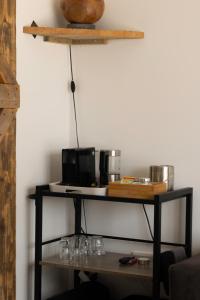 een plank met glazen en een magnetron aan de muur bij BnB Purmerland in Purmerend