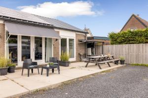 een patio met een picknicktafel en stoelen bij BnB Purmerland in Purmerend