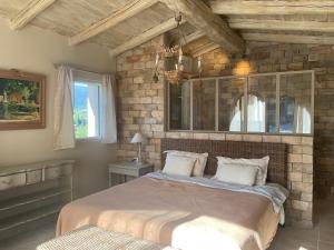 a bedroom with a bed and a brick wall at L'Irisciabella in Lourmarin +60 photos