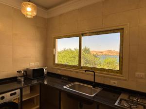 a kitchen with a sink and a large window at Golden Sun House II in Abu Simbel +18 photos