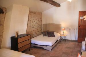 una camera con letto e cassettiera di Grande maison Art Nouveau entre mer & garrigue, charme et loisirs au cœur du Sud a Gabian