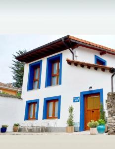 a blue and white house with a orange door at La Mar de Nueva AT in Nueva de Llanes