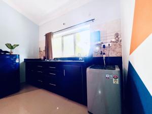 a small kitchen with a sink and a refrigerator at Stunning 4bhk Pool View Apartment 2bhkX2 in Vagator