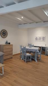 a dining room with a table and chairs and a clock at La Mar de Nueva AT in Nueva de Llanes