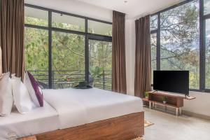 a bedroom with a large bed with a tv and large windows at The Pine hill Apartments by Hill crest kasauli in Dharampur