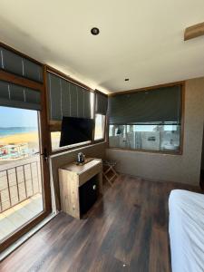 a bedroom with a bed and a tv and windows at Goga Otel in Sarıyer +150 photos