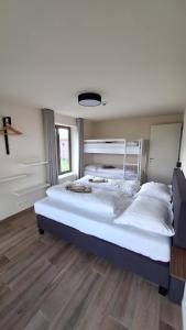two beds in a bedroom with wooden flooring at Sotteveld in Zwalm