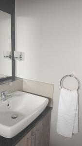 ein Bad mit einem Waschbecken, einem Spiegel und einem Handtuch in der Unterkunft The Eyrie in Nelspruit