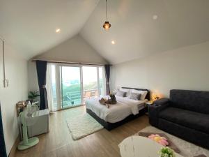 a living room with a bed and a couch at Memory House ภูชี้ฟ้า เชียงราย in Ban Seng Choi