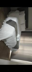 ein Bett mit weißen Kissen und einer Decke darauf in der Unterkunft The Eyrie in Nelspruit