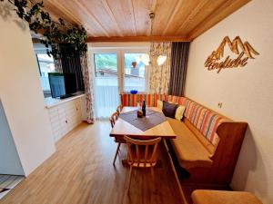 a living room with a table and a couch at Haus Daheim in Sankt Leonhard im Pitztal