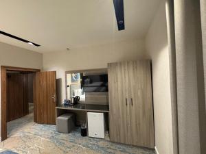 a room with a kitchen with wooden cabinets at Niyama Hotel in Umm Lajj