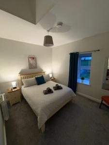 ein Schlafzimmer mit einem Bett mit zwei Hausschuhen darauf in der Unterkunft Patsys Cottage in Ballyshannon