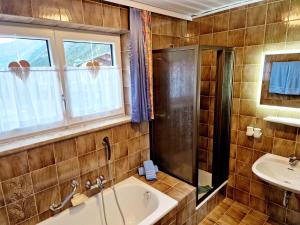 a bathroom with a tub and a sink at Haus Daheim in Sankt Leonhard im Pitztal +37 photos