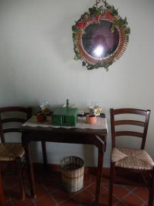 una mesa con 2 sillas y un espejo en la pared en Agriturismo I Muri, en Monte Santa Maria Tiberina