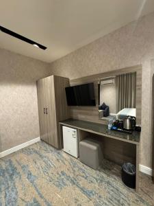 Una habitación de hotel con un escritorio y una cama. en Niyama Hotel, en Umm Lajj 21 fotos más