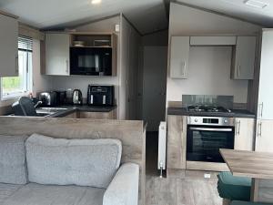 a kitchen and living room with a couch and an oven at 30 Wells Close in Cheswick