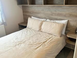 a bed with white sheets and pillows in a bedroom at 30 Wells Close in Cheswick