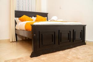 a black bed with orange pillows in a room at Urban charm Nakuru in Nakuru +5 photos