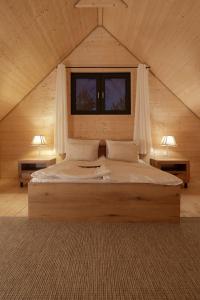 a bedroom with a large bed in a wooden cabin at Żurawia Ostoja Dom z Jacuzzi i Sauną in Tyłowo