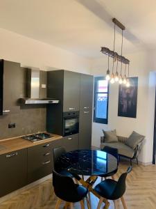 a kitchen with a glass table and chairs in a room at Casa Amore Design - South Sardinia - in San Gavino Monreale