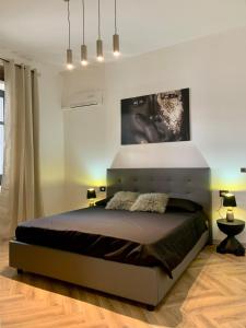 a bedroom with a bed and a large painting on the wall at Casa Amore Design - South Sardinia - in San Gavino Monreale