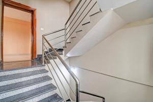 a staircase in a house with a metal railing at Hotel O Relax Inn in Jānla