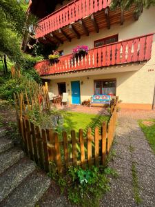 une maison avec une clôture en bois devant dans l'établissement Ferienhaus Robin, à Titisee-Neustadt 63 autres photos