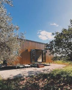 Un edificio con dos mesas y sillas delante. en Tiny House, en Pereiro