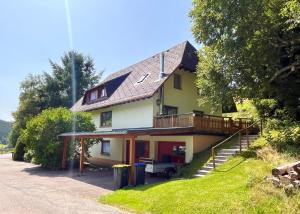 a yellow house with a balcony and a porch at Ferienhaus Robin in Titisee-Neustadt