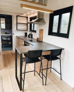a kitchen with a black table and two chairs at Tiny House in Pereiro +6 photos