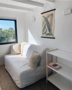 Sofá blanco en una habitación con ventana en Tiny House, en Pereiro