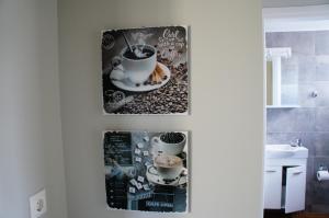 ein Badezimmer mit zwei Bildern von Kaffeetassen in der Unterkunft A&I Apartments & Studios in Athen + 40 Fotos