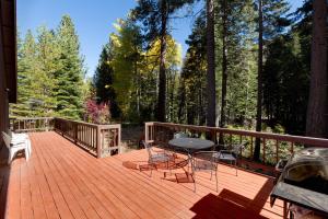 a wooden deck with a table and chairs on it at Spacious Riverfront home in Nebelhorn