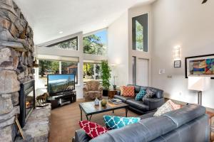 a living room with a couch and a stone fireplace at Spacious Riverfront home in Nebelhorn