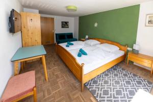 a bedroom with a bed and a table in it at Goldiger Hirsch Pension mit Gemeinschaftsküche in Immenstadt im Allgäu