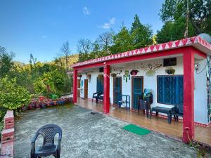 a red and white house with a deck at Far out Homestay in Hawālbāgh