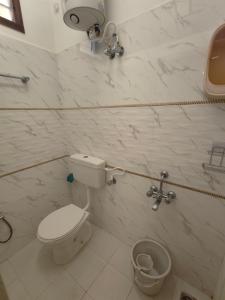 a bathroom with a toilet and a trash can at Buddha Home stay in Mahabalipuram