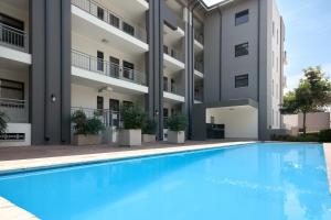 a swimming pool in front of a building at The Atrium, Sandton Apartment in Johannesburg