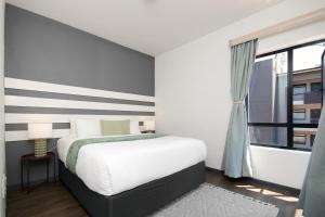 a bedroom with a large bed and a window at The Atrium, Sandton Apartment in Johannesburg +24 photos