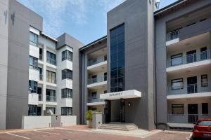 an apartment building with a car parked in front of it at The Atrium, Sandton Apartment in Johannesburg