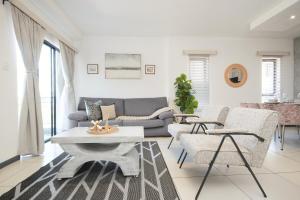 a living room with a couch and a table and chairs at The Atrium, Sandton Apartment in Johannesburg