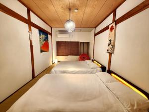 a room with two beds in it at D,A-House OSAKA in Osaka