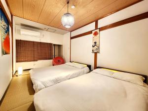 a room with two beds and a window at D,A-House OSAKA in Osaka